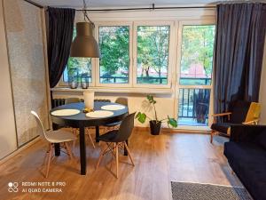 a living room with a table and chairs and windows at Studio Park Śląski Katowice/Chorzów in Chorzów