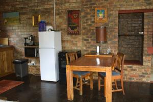 a kitchen with a wooden table and a white refrigerator at Hangman's Lookout in Calitzdorp