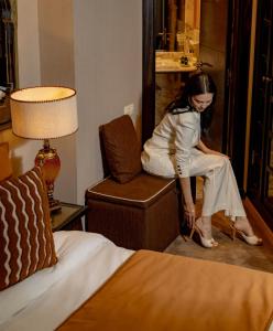 a woman sitting on a chair in a hotel room at Art Palace Suites & Spa in Casablanca