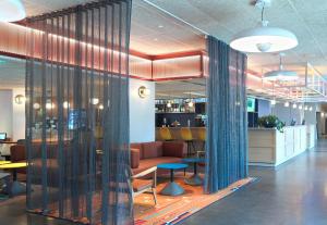 a lobby with a waiting area with chairs and tables at B&B HOTEL Paris 17 Batignolles in Paris