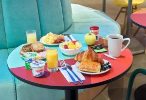 a red table with breakfast foods and drinks on it at B&B HOTEL Paris 17 Batignolles in Paris