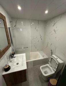 a bathroom with a sink and a toilet and a tub at Mon Refuge 123 in Bcharré +1 photo