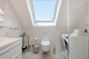 a bathroom with a toilet and a sink and a window at Grachtenrefugium in Greetsiel +24 photos