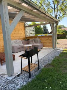 a barbecue grill on a table under a pergola at The Country Stop Apartment in Łęki +31 photos