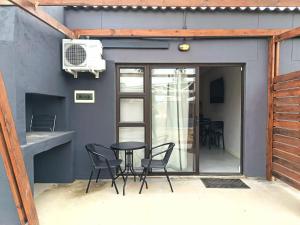 a patio with chairs and a table and a fan at Unit 7 Dinas Accommodation Oranjemund in Oranjemund