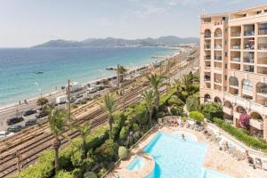 a resort with a swimming pool and a beach at Résidence La Palme d’Azur – Cannes in Cannes