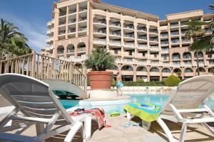 two chairs and a swimming pool in front of a building at Résidence La Palme d’Azur – Cannes in Cannes +36 photos