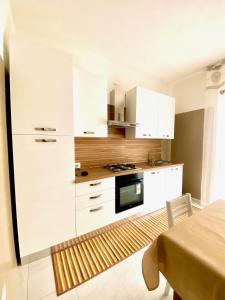 a kitchen with white cabinets and a stove top oven at La Lidia in Sassari