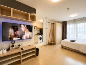 a bedroom with a bed and a flat screen tv at Easy Access Studio Near BTS in Amphoe Phra Khanong