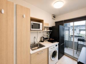 a small kitchen with a sink and a microwave at Easy Access Studio Near BTS in Amphoe Phra Khanong