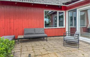 a patio with a couch and a chair next to a red house at 2 Bedroom Pet Friendly Home In Haderslev in Haderslev +8 photos