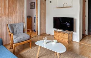 a living room with a tv and a chair and a coffee table at 2 Bedroom Pet Friendly Home In Haderslev in Haderslev