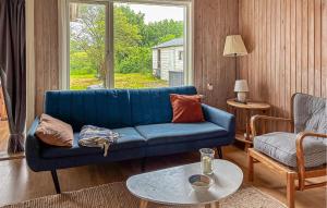 a living room with a blue couch and a table at 2 Bedroom Pet Friendly Home In Haderslev in Haderslev
