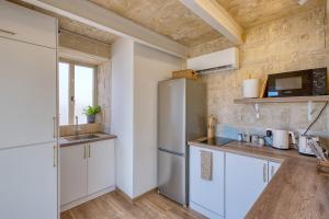 a kitchen with white cabinets and a refrigerator at Dar Vitorja in Senglea