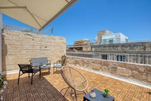 a patio with two chairs and a tennis racket at Dar Vitorja in Senglea