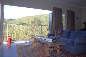 a living room with a blue couch and a coffee table at Hangman's Lookout in Calitzdorp