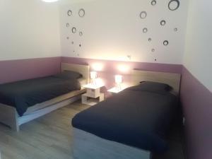 two beds in a small room with two lamps at Gîte Aux 3 Épis, Classé 3 Étoiles in Dienville