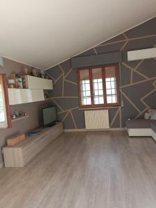 a living room with a tv and a geometric wall at La Rondine Atessa in Atessa