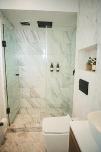 a white bathroom with a shower and a toilet at Icon 701- Stylish Loft W AC Premium Location in Mexico City