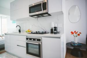 a kitchen with a stove and a microwave at Icon 701- Stylish Loft W AC Premium Location in Mexico City +11 photos