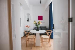 a dining room with a table with chairs and a vase of flowers at Icon 701- Stylish Loft W AC Premium Location in Mexico City