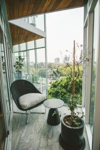 a balcony with a table and a chair and a tree at Icon 701- Stylish Loft W AC Premium Location in Mexico City