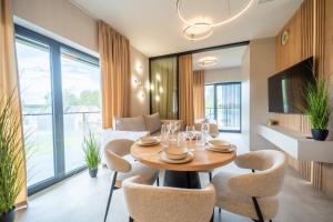 a dining room with a table and chairs at Apartament K&M 13 in Mikołajki