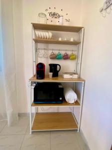 a shelf with a microwave in a room at La Lidia in Sassari