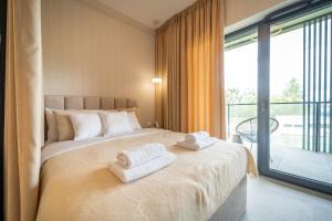 a bedroom with a large bed with towels on it at Apartament K&M 13 in Mikołajki
