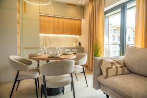 a living room with a table and chairs and a couch at Apartament K&M 13 in Mikołajki