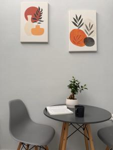 a table and chairs in a room with paintings on the wall at Tête à Tête - Loft Apartment in Rhodes Town +33 photos