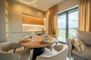 a kitchen and dining room with a table and chairs at Apartament K&M 13 in Mikołajki +17 photos