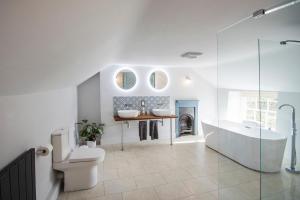 a bathroom with a tub and a toilet and a sink at Cusgarne Manor boutique B&B - adults only in Cusgarne