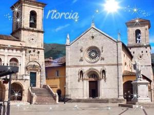 a church with two towers and a clock on it at I due archi in Norcia +28 photos