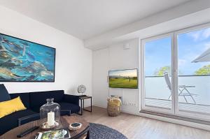 ein Wohnzimmer mit Sofa und großem Fenster in der Unterkunft 3002 - Grömitz in Grömitz