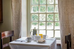a table with a plate of food and a window at Cusgarne Manor boutique B&B - adults only in Cusgarne