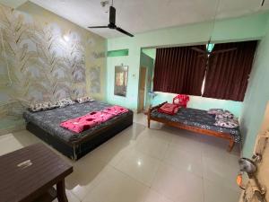 a bedroom with two beds and a bench in it at Hotel HillView, Junagadh in Junagadh