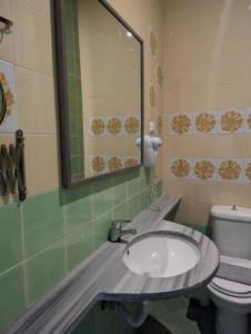a bathroom with a sink and a toilet and a mirror at Okeania Seafront Rooms in Kamena Vourla in Kamena Vourla +117 photos