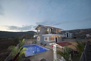 a house with a swimming pool in front of it at II EMPYREAN STAYS II LEONCINO VILLA II 4BHK II LARGEST SWIMMING POOL II AC Il in Lonavala