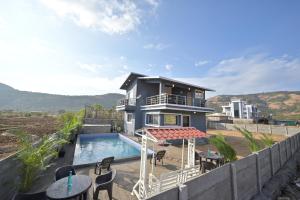 a house with a swimming pool next to a building at II EMPYREAN STAYS II LEONCINO VILLA II 4BHK II LARGEST SWIMMING POOL II AC Il in Lonavala