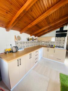 a kitchen with white cabinets and a wooden ceiling at Ceres26 in Fethiye