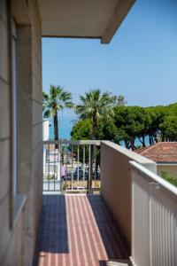 a balcony with a view of the ocean and palm trees at MD Beach Home in Roseto degli Abruzzi