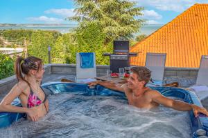 a man and a girl in a hot tub at Apartman 360 in Balatonalmádi
