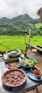a table with plates of food on a table with a view at เวนิสบ้านเวร in Ban Khun Nam Nan