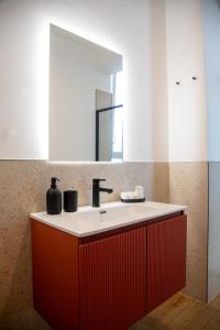 a bathroom with a red sink and a mirror at MD Beach Home in Roseto degli Abruzzi