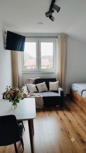 a living room with a couch and a window at The Country Stop Apartment in Łęki