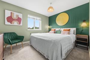 a bedroom with a bed and a green wall at CHERRYTREES Beautiful 5 Bedrooms, Sleeps 9, 3 Bathrooms, Parking, Ideal for Groups and Work Stays in Corby