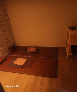 two beds in a room with a wooden floor at GoodDay Jjimjilbang in Incheon
