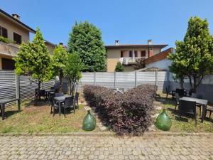 a patio with tables and chairs and a fence at Michelangelo Appartamenti con parcheggio gratuito self check in WI FI GRATUITO MODERNO ARIA CONDIZIONATA NUOVA GESTIONE in Cormano