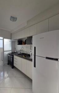 a kitchen with a refrigerator and a stove at terraços do maitinga in Bertioga